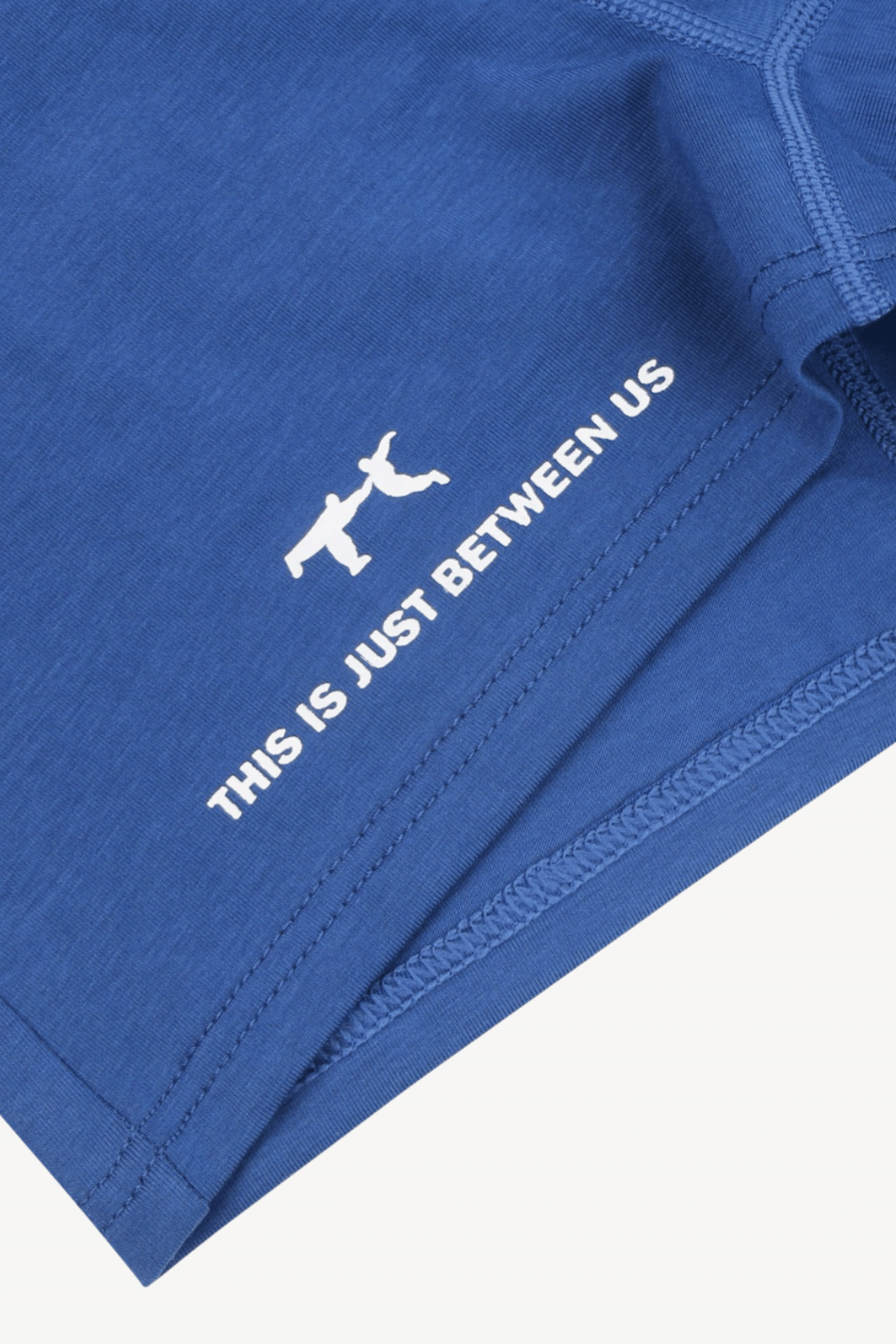 Blue fabric with white text and logo on a white background. THIS IS JUST BETWEEN US and logo icons in organic cotton and modal fabric