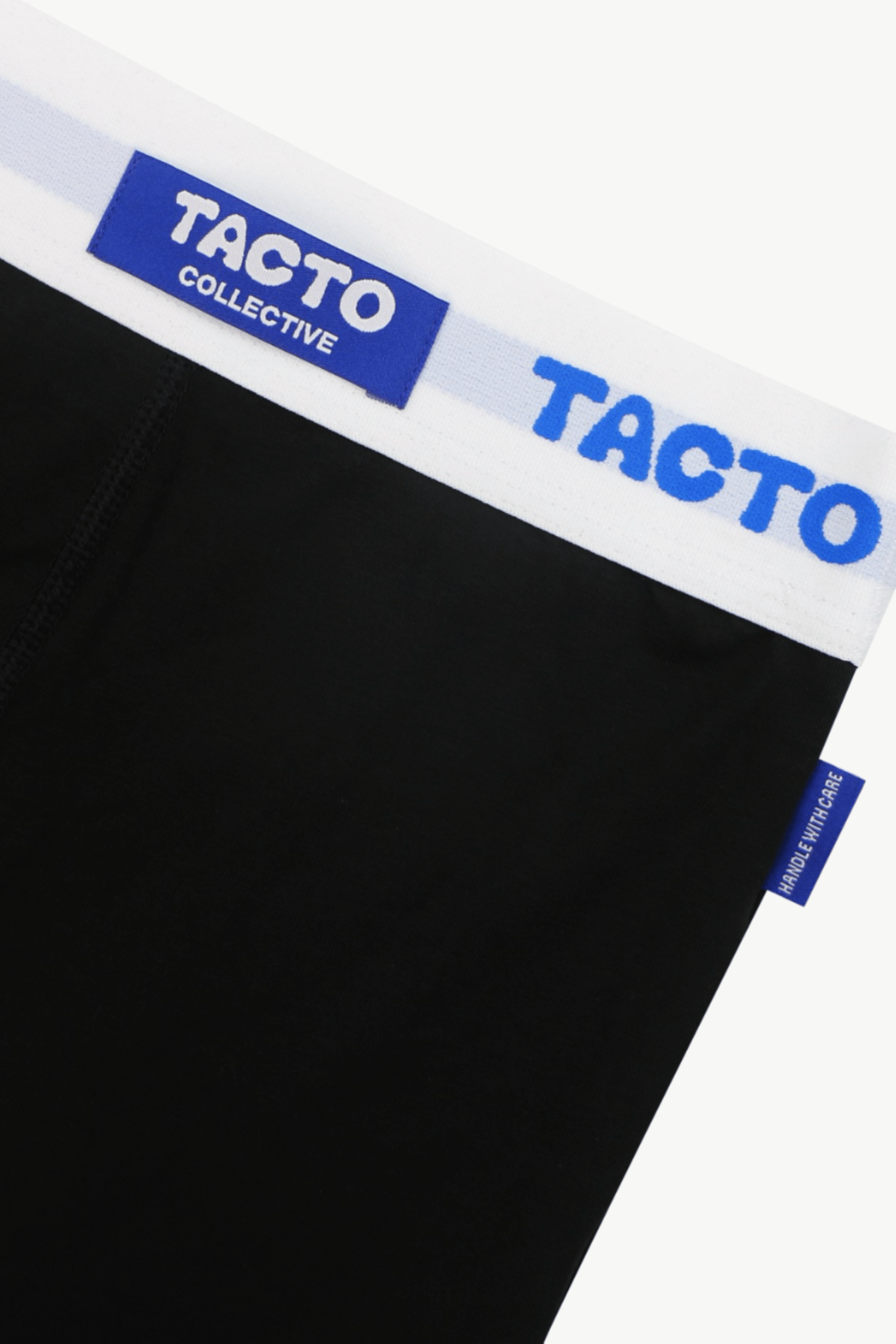 Black boxer briefs with blue and white waistband featuring 'Tacto' branding, and side tag that says Handle with care.