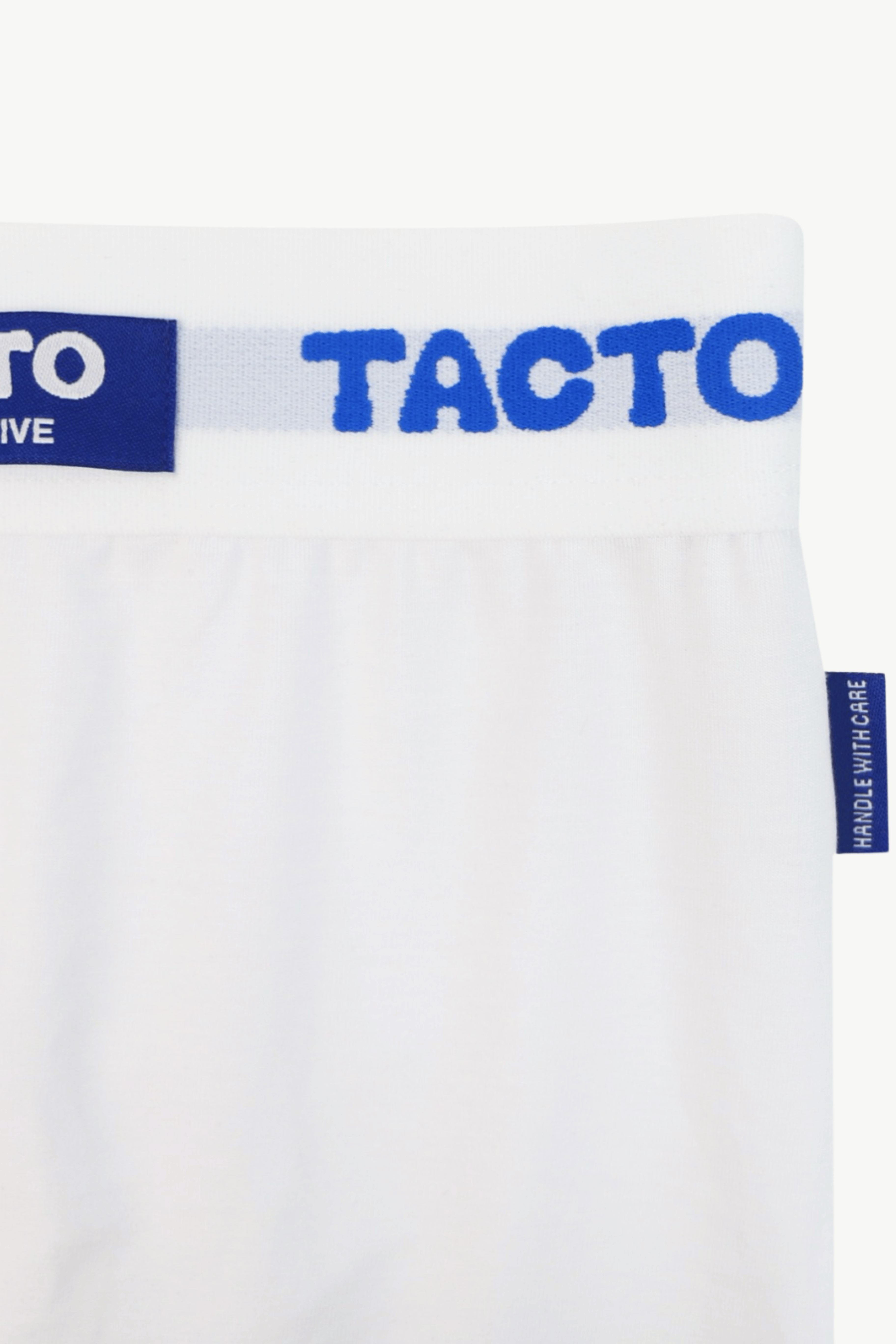 White underwear with blue 'TACTO' branding on a white background. The Pressing Men's Underwear Boxer Brief White Signature TACTO Waistband and Tag Details Organic Cotton-Modal, No Polyester — TACTO Collective