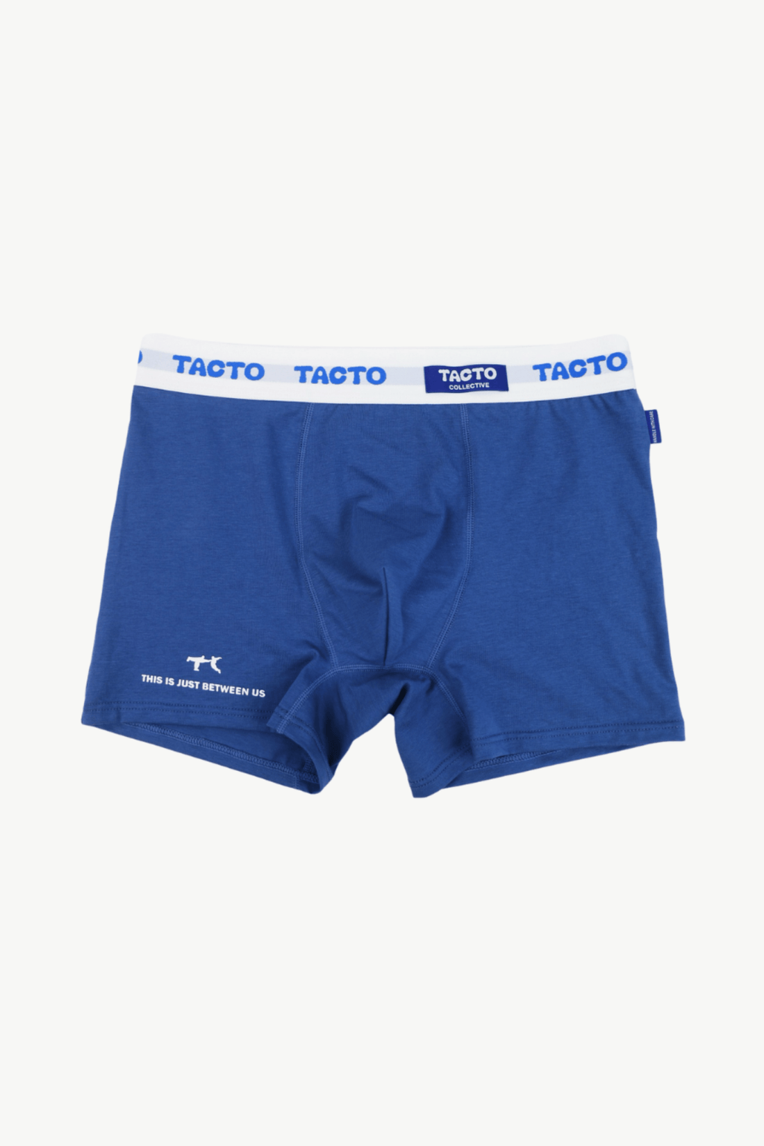 Man wearing blue boxer briefs with a visible brand logo against a plain background. TACTO Collective underwear.