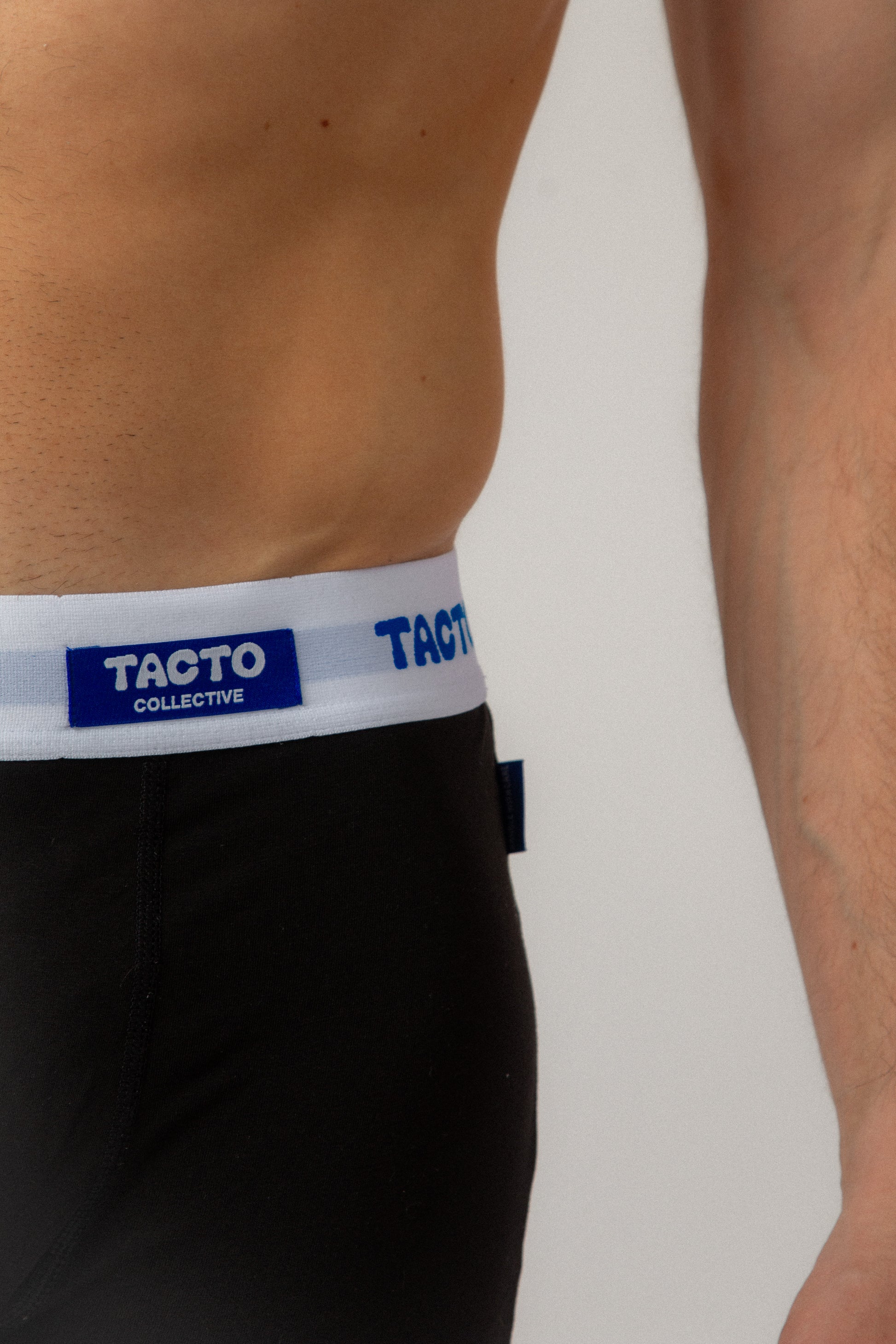 Person wearing black underwear with Tacto Collective waistband on a plain background