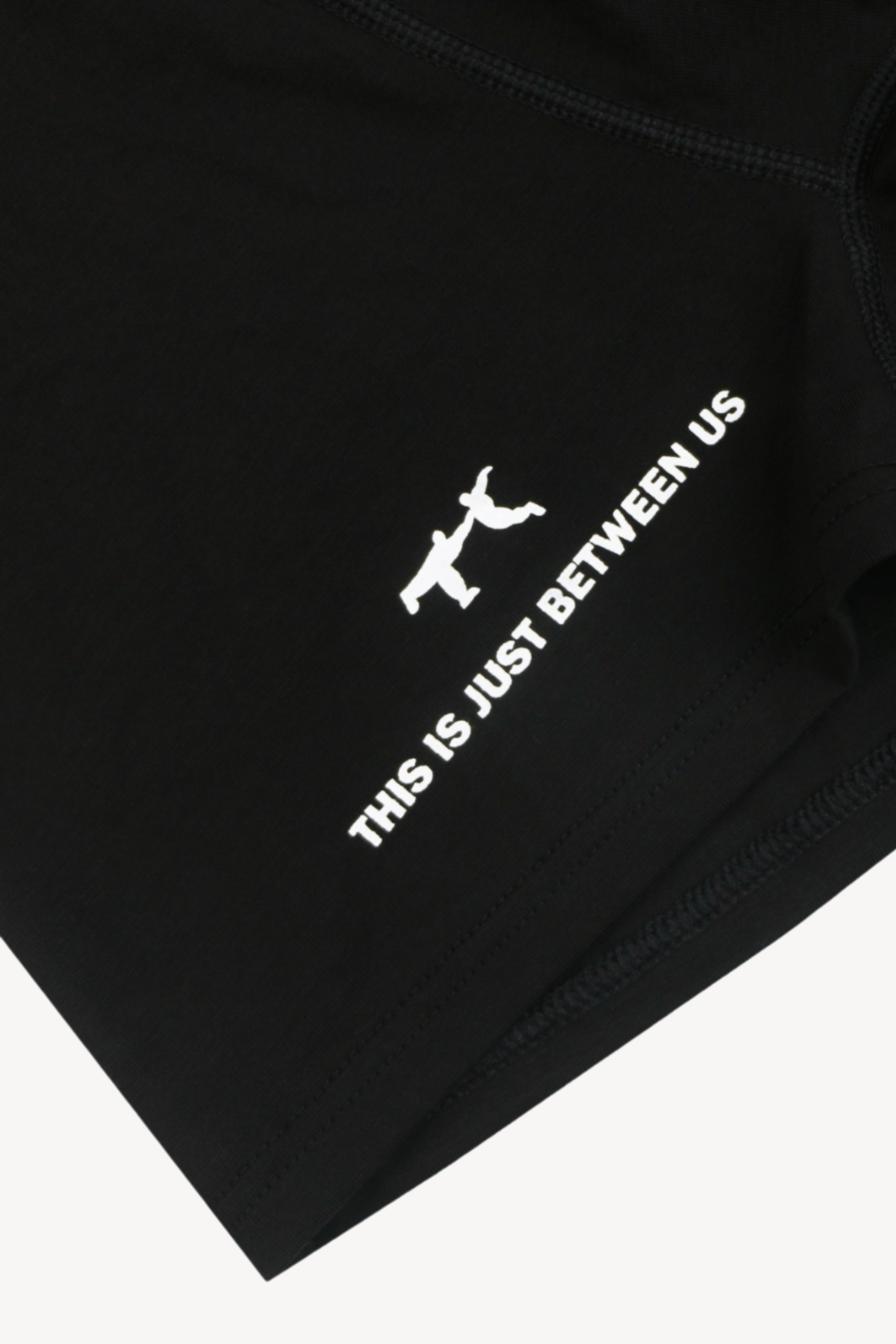 Black garment with white text and logo on a white background. The Remix Men's Underwear Black Boxer Brief Organic Cotton-Modal, No Polyester Logo Detail in White THIS IS HYST BETWEEN US — TACTO Collective